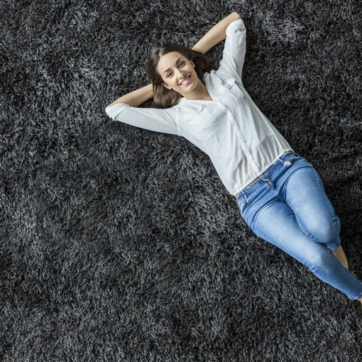Lady laying on black carpet | Bell County Flooring